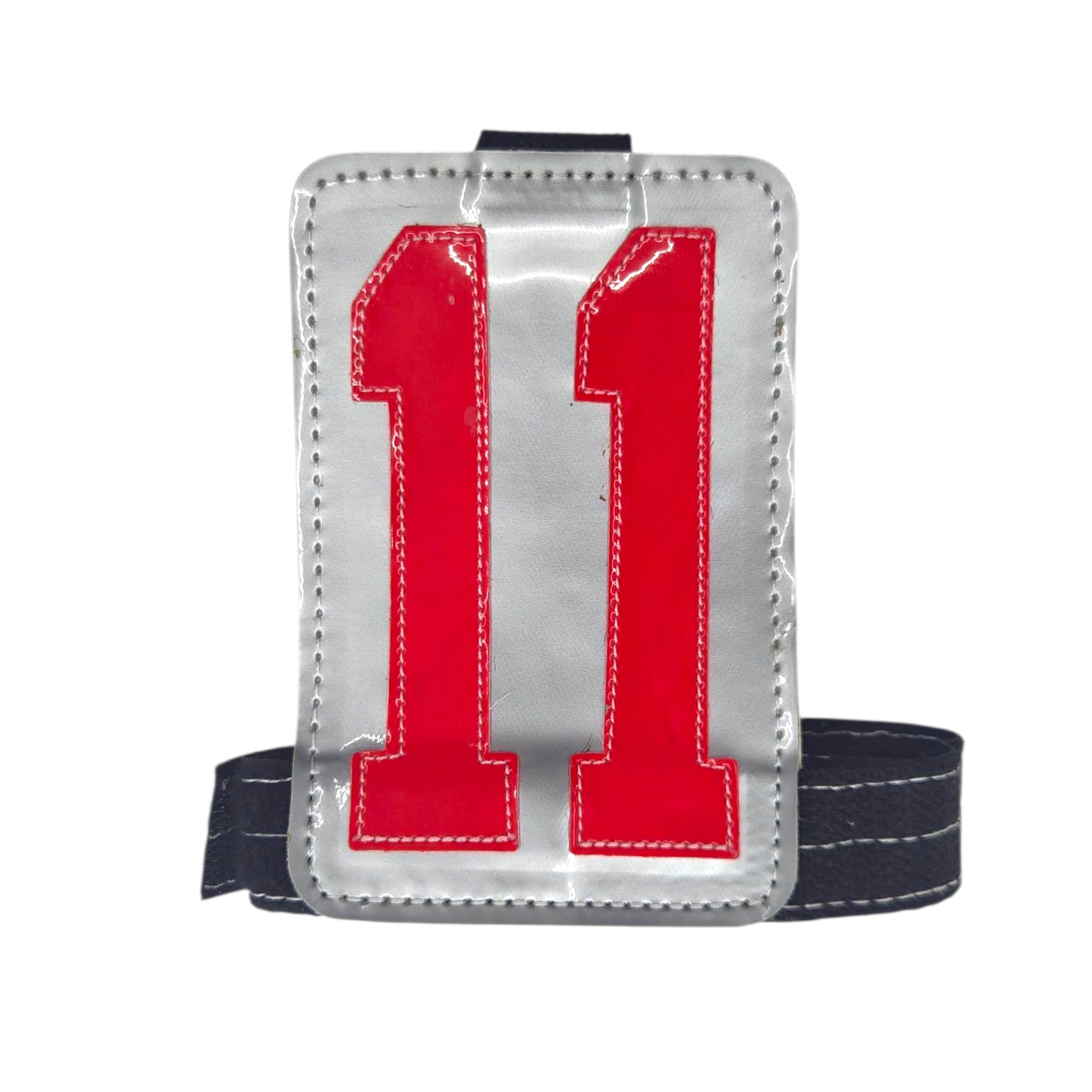 Silver sports jersey number 11 patch with red digits and a black strap.