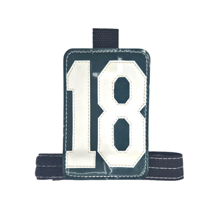 Green sports bib featuring the number 18 with a black adjustable strap.
